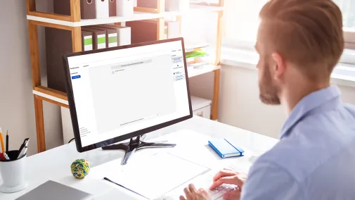 Mann am Computer mit Assistent.IQ Mann am Computer arbeitet mit KI Tool für Verwaltung Assistent.IQ der Bundesdruckerei