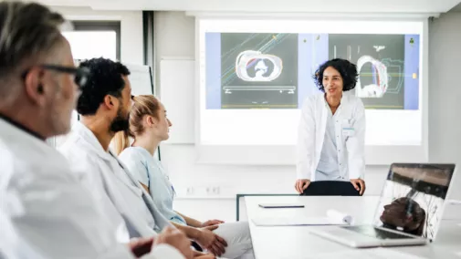 Ärzte Frau und Mann im Meeting sitzend am Tisch in Klinik Ärzte Frau und Mann im Meeting sitzend am Tisch in Klinik