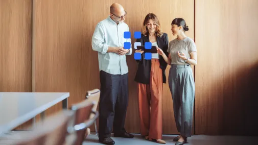 Drei Personen stehen und sprechen miteinander.