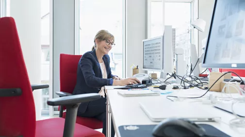 Frau sitzt am Computer im Büro Frau sitzt am Computer im Büro