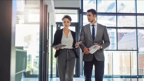 women and man with tablet walking at the office