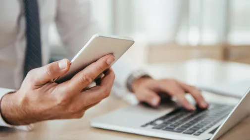 Mann in den Händen ein Smartphone mit Notebook Mann in den Händen ein Smartphone mit Notebook
