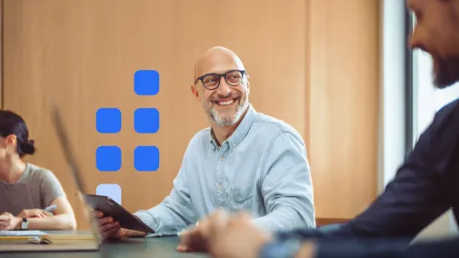 Ein Mann hält ein Ipad in der Hand und lächelt.