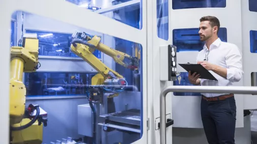 Mann mit Tablet bedient Maschine in Fabrik Mann mit Tablet bedient Maschine in Fabrik