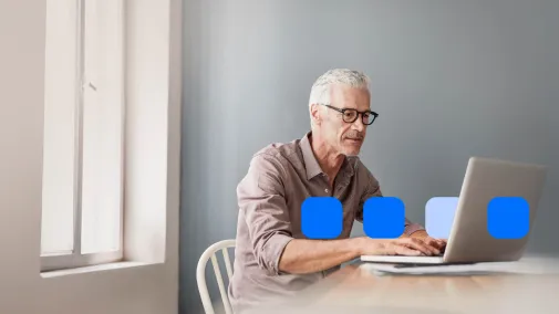 Mann sitzt am Notebook, kleine Pixel sind darum abgebildet