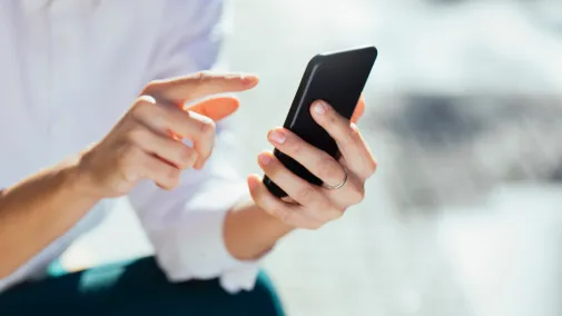 A Woman is tapping on a smartphone.