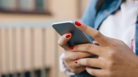 Frauenhände mit Smartphone draussen