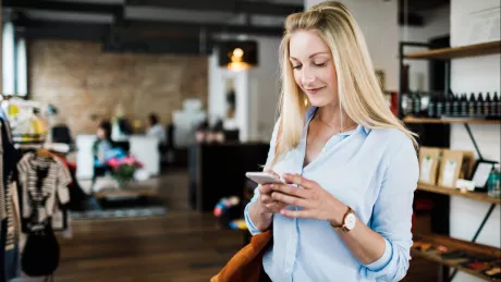 women with smartphone staying in a shop