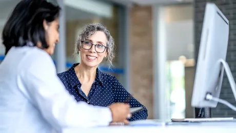 Zwei Frauen sitzen an einem Tisch Zwei Frauen sitzen an einem Tisch