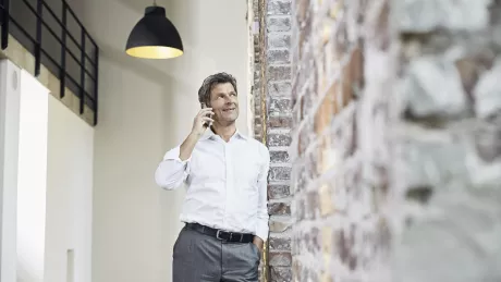 man smartphone standing on a wall in office