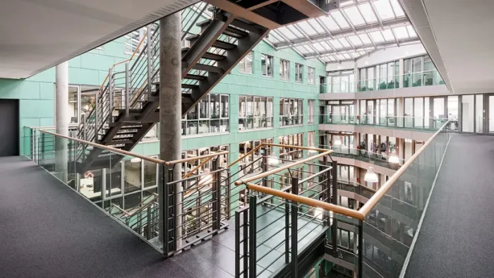 Photo of the interior of a Bundesdruckerei Group building with a view of a staircase and offices in the background