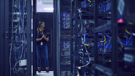 Frau mit Klemmbrett in Serverraum