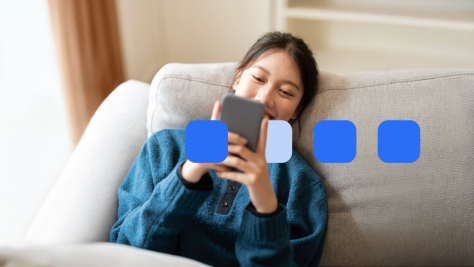 Woman lying on sofa looking at mobile phone.